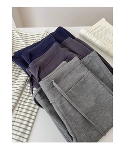 Vista piatta di pantaloni sportivi ampi in blu, viola e grigio con trama a maglia morbida