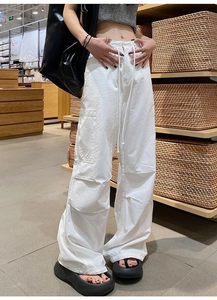 Détail du pantalon cargo blanc avec poches latérales à rabat et taille à cordon réglable