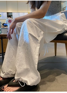 Détail du pantalon cargo blanc avec ourlets à cordon réglable et texture en coton et lin