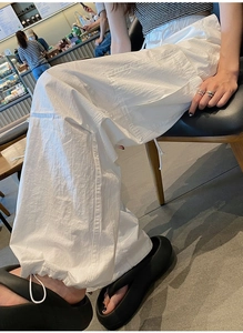 Détail du pantalon cargo blanc avec grandes poches latérales et ourlet à cordon réglable