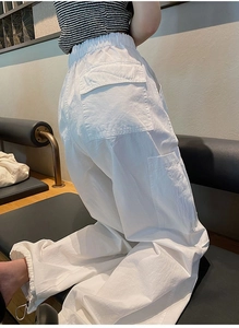 Détail du pantalon cargo blanc avec taille élastique à cordon et grande poche arrière