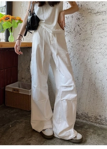 Gros plan détaillé du pantalon cargo blanc avec taille à cordon et poche latérale à rabat