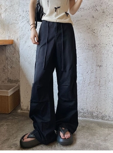 Détail du pantalon cargo noir à jambes larges avec cordon de serrage et poches cargo