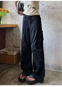 Détail du pantalon cargo noir avec coupe large, taille à cordon et poches utilitaires