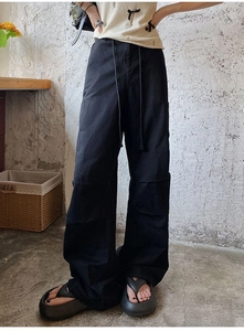 Détail de la taille élastique à cordon et des plis aux genoux du pantalon cargo noir