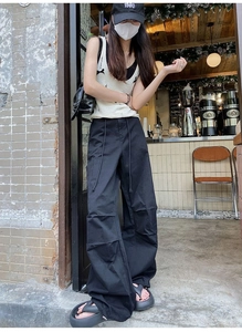 Vue en extérieur d'un pantalon cargo blanc ample avec coupe droite et taille à cordon
