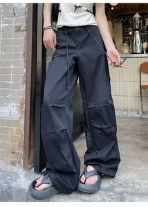 Détail d'un pantalon cargo noir à jambes larges avec poches latérales et cordon de serrage