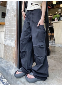 Détail du pantalon cargo noir à jambes larges avec poches tactiques et taille à cordon