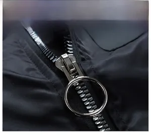 Detailed macro shot of a size 10 silver metal zipper with large ring puller on black fabric