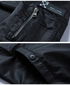 Detail of arm zipper pocket and snap button closure on black MA1 pilot jacket