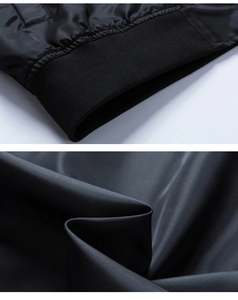 Close-up detail of black bomber jacket featuring elastic ribbed cuffs and smooth fabric texture