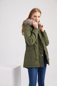 Détail de la parka vert olive avec bordure en fausse fourrure et taille à cordon