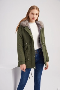 Détail de la parka vert armée avec doublure en fausse fourrure grise et cordon à la taille