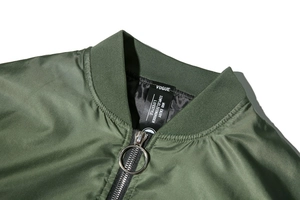 Close-up of military green bomber jacket featuring ribbed collar and ring zipper puller