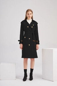 Détail d'un long trench-coat noir croisé avec ceinture ajustable et boutons dorés élégants