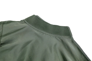Close-up of the ribbed knit collar and satin finish fabric on army green bomber jacket