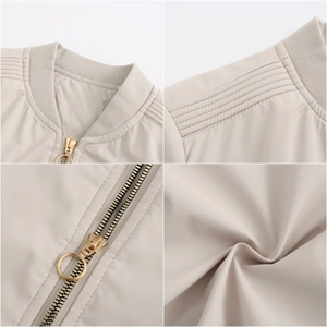 Detail of beige quilted jacket with rib-knit collar and gold-tone metal ring zipper