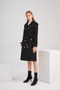 Détail d'un trench-coat noir à double boutonnage avec ceinture et col à revers élégant
