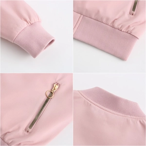 Detail view of pink jacket showing ribbed cuffs, hem and golden ring zipper puller