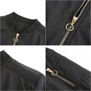 Detail of black bomber jacket with gold zipper ring and ribbed collar textures