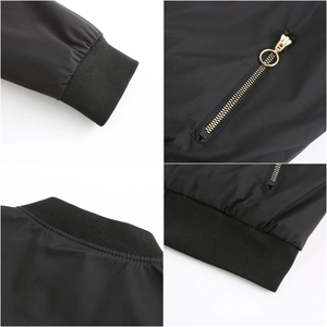 Detail of black bomber jacket featuring ribbed knit cuffs and a golden metal zipper pocket