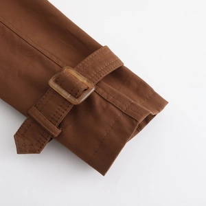 Détail des poignets ajustables avec boucle en écaille et coutures soignées