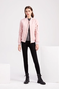 Detailed full body shot of pink bomber jacket paired with black leggings and boots