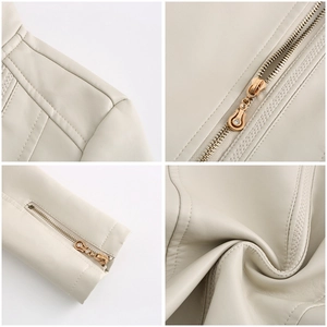 Detail of light beige PU leather jacket featuring golden zippers and rhinestone puller