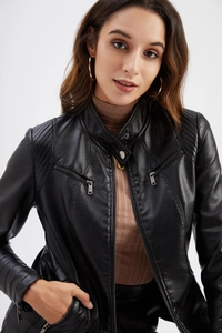 Détails d'une veste de motard en similicuir noir avec textures matelassées et boutons pressions