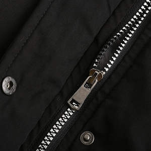 Detail of high-quality metal zipper and snap button on black parka jacket fabric