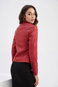 Détails des surpiqûres aux épaules et de la texture en cuir synthétique rouge du blouson