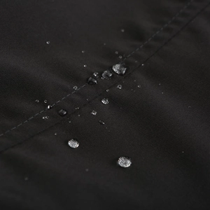 Détail macro du tissu noir imperméable de la parka avec perles d'eau et double couture