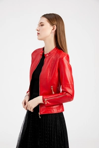 Detail of red faux leather jacket featuring stand collar and golden zipper accents