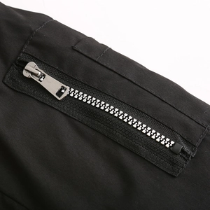 Detailed macro view of the premium silver metal zipper and stitching on the black parka
