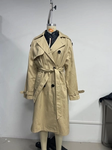Vue détaillée du trench-coat kaki pour femme avec double boutonnage, ceinture et col à revers