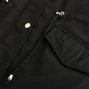 Detail of parka jacket showing silver snap buttons, black woven drawstring, and pocket flap