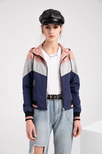 Detail of color block hooded jacket featuring pink and grey patchwork with striped cuffs