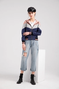 Women's color-block hooded windbreaker styled with ripped jeans and black boots