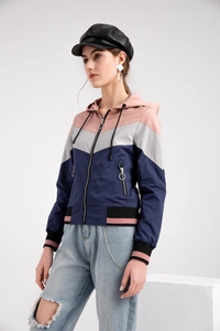 Detail of color-block windbreaker featuring pink, grey, and navy panels with zip puller
