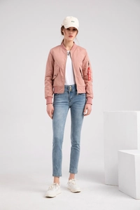Detail of pink bomber jacket showing red flight tag on sleeve with white cap and blue jeans