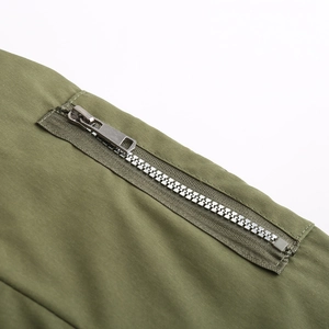 Détail de la fermeture éclair en argent et du tissu tissé vert olive d'une parka d'hiver