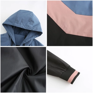 Detail view of hooded windbreaker featuring tricolor splicing and ribbed cuffs