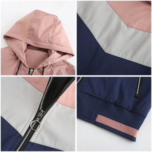 Detail view of hooded color-block windbreaker showing metal zippers and ribbed cuffs