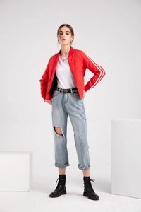 Detail of red bomber jacket featuring classic white side stripes on sleeves for sporty look