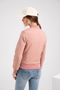 Detail of pink bomber jacket showing zippered sleeve pocket and ribbed cuffs on model
