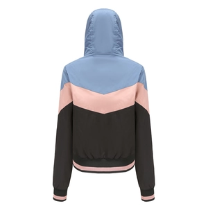 Women's hooded windbreaker featuring blue, pink and black patchwork from back view