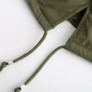 Détail du parka vert olive avec cordon de serrage tissé et embouts métalliques
