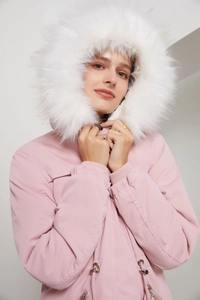 Détail de la parka rose avec col en fourrure pelucheuse, cordon de serrage et poignets côtelés
