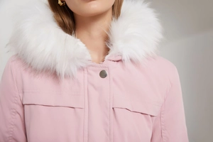 Vue détaillée de la parka rose pour femme avec col en fausse fourrure blanche et poche