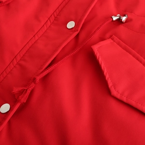 Détail de la parka rouge avec boutons-pression argentés et cordon de serrage avec embouts